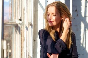 Close-up portrait shot of beautiful woman looking thoughtfully while standing by the window and relaxing.